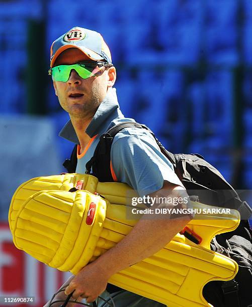 Australian cricketer Michael Clarke carries his batting gear to a training session at the National Cricket Academy in Bangalore on February 14 ahead...