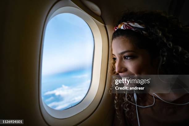 woman traveling by airplane and listening to music - plane window stock pictures, royalty-free photos & images