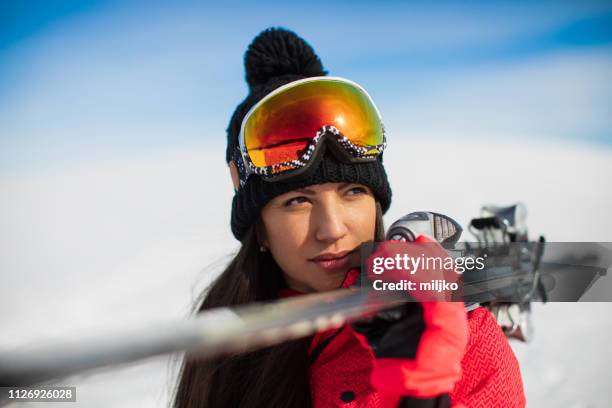 one woman carrying ski on mountain - woman skiing stock pictures, royalty-free photos & images