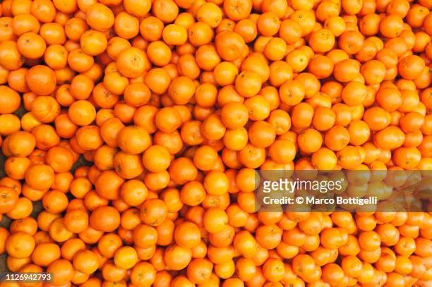 fresh tangerines on a market stall - orange color - fotografias e filmes do acervo
