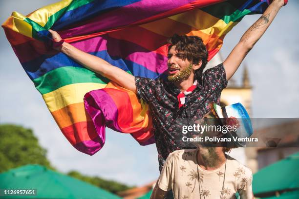 gay paar houden de lgbt markeren - gay flag stockfoto's en -beelden