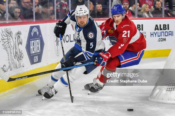Cameron Schilling of the Manitoba Moose and Dale Weise of the Laval Rocket racing for the puck from behind the net at Place Bell on February 23, 2019...