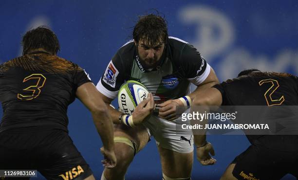 South Africa's Bulls lock Lood De Jager is tackled by Argentina's Jaguares prop Santiago Medrano and hooker Agustin Creevy during their Super Rugby...