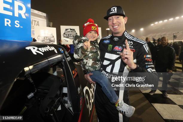 Kyle Busch, driver of the Cessna Toyota, celebrates with his son Brexton by placing the Winner's sticker on his car after winning the NASCAR Gander...