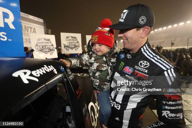 Kyle Busch, driver of the Cessna Toyota, celebrates with his son Brexton by placing the Winner's sticker on his car after winning the NASCAR Gander...