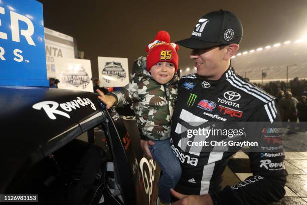 Kyle Busch, driver of the Cessna Toyota, celebrates with his son Brexton by placing the Winner's sticker on his car after winning the NASCAR Gander...