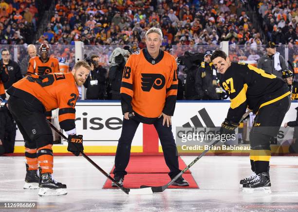 Professional football coach Doug Pederson waits to drop the puck for the ceremonial opening face-off between Claude Giroux of the Philadelphia Flyers...