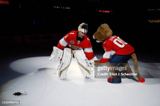 Goaltender Roberto Luongo of the Florida Panthers low fives team mascot Stanley C. Panther after their 6-1 win over the Los Angeles Kings at the BB&T...