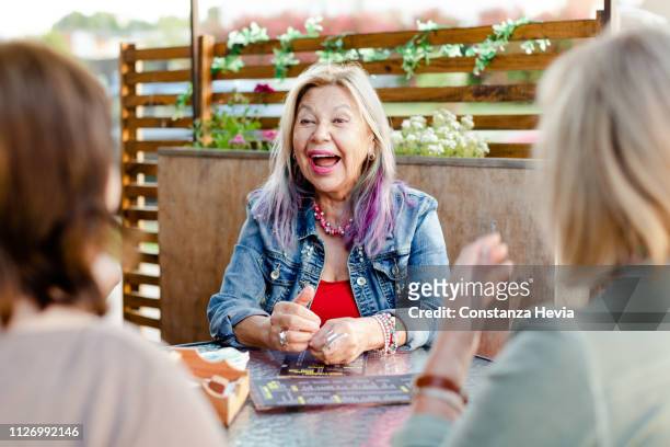senior woman having fun with friends at restaurant - senior colored hair stock pictures, royalty-free photos & images