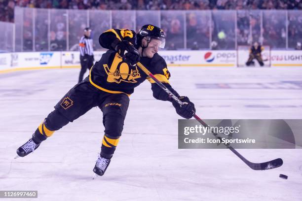 Jake Guentzel of the Pittsburgh Penguins takes a shot on net in overtime during the Stadium Series game between the Pittsburgh Penguins and the...