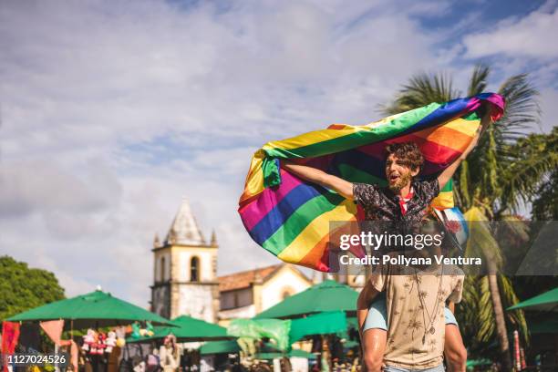 coppia gay con in mano la bandiera lgbt - diritti degli omosessuali foto e immagini stock