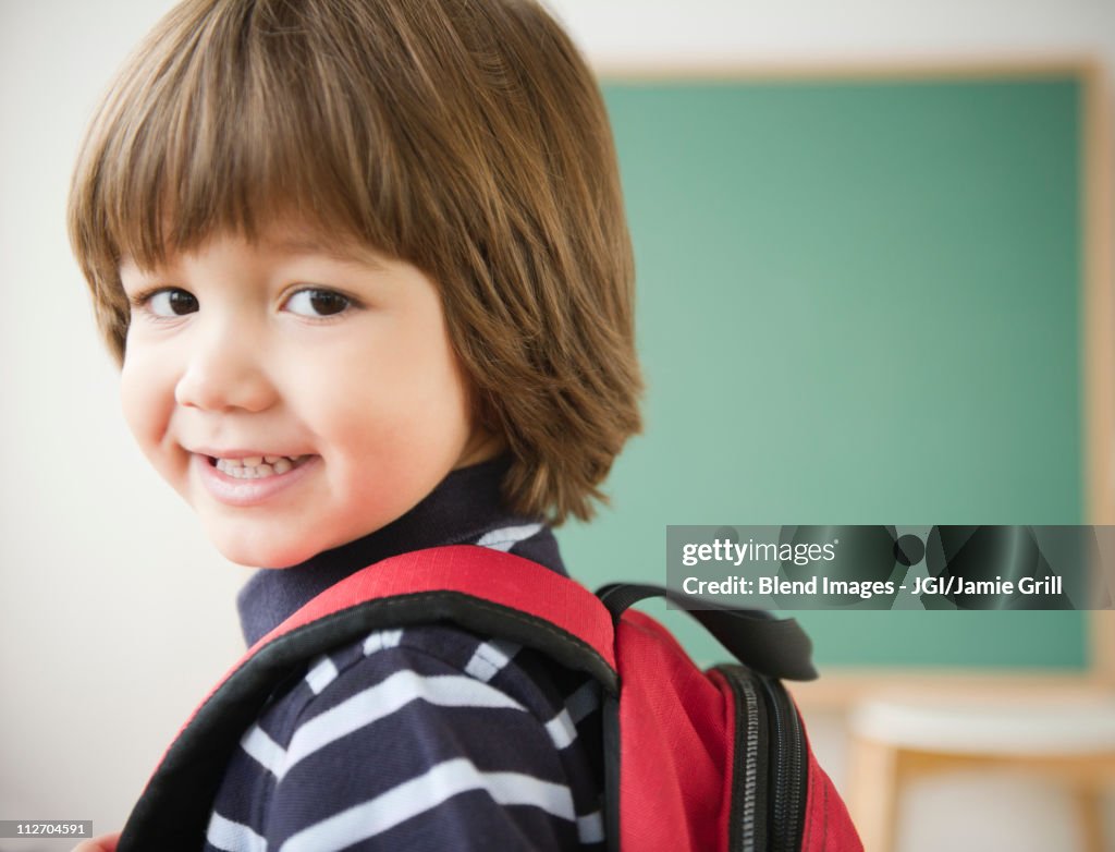 Smiling Hispanic boy wearing backpack