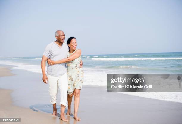 black couple enjoying beach together - barefoot black men stock pictures, royalty-free photos & images