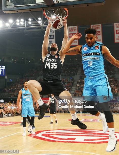 Alex Pledger of United slam dunks the ball against Corey Webster of the Breakers during the round 16 NBL match between Melbourne United and the New...