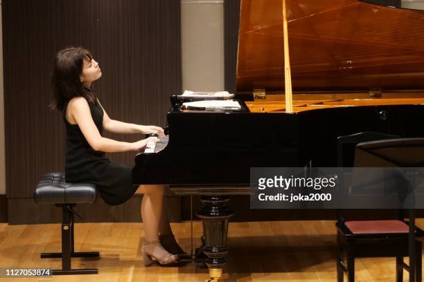 pianist palying musik im kleinen raum - soloist stock-fotos und bilder
