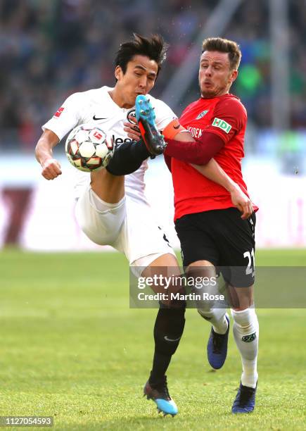 Makoto Hasebe of Eintracht Frankfurt battles for possession with Nicolai Muller of Hannover 96 during the Bundesliga match between Hannover 96 and...