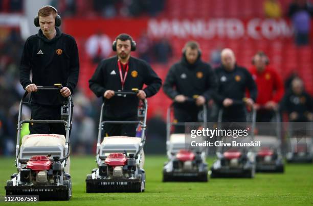 Groundstaff cut the grass after the Premier League match between Manchester United and Liverpool FC at Old Trafford on February 24, 2019 in...