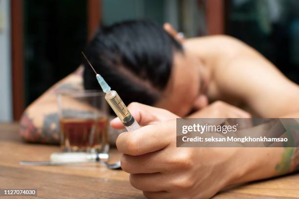 asian men are drug addicts to inject heroin into their veins themselves.flakka drug or zombie drug is dangerous life-threatening,thailand no to drug concept,the bad guy drugs in the desolate - marijuana arrest stock pictures, royalty-free photos & images