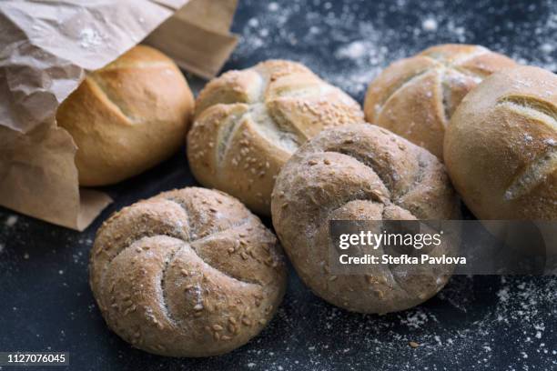 freshly baked mixed bread rolls in a paper bag - flour bag stockfoto's en -beelden