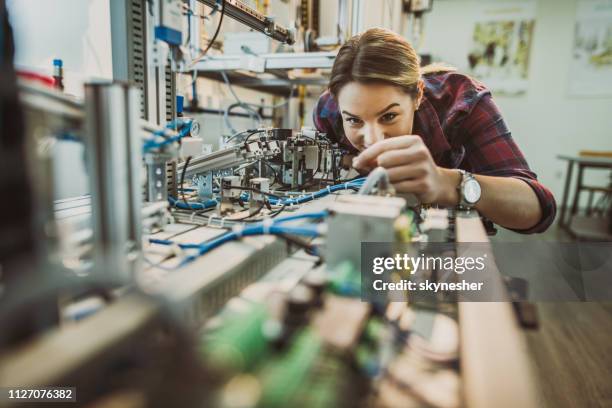 happy engineering student examining part of production line in a laboratory. - electronics engineering students stock pictures, royalty-free photos & images