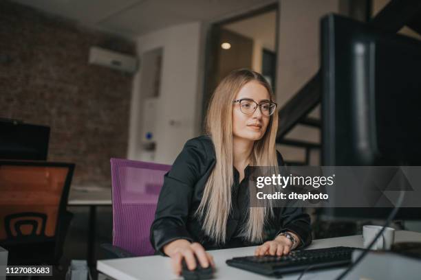 businesswoman using computer and drink coffe at desk - blue spectacles stock pictures, royalty-free photos & images