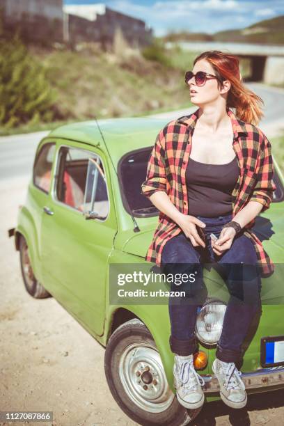 redhead girl sitting on car hood - car top down stock pictures, royalty-free photos & images