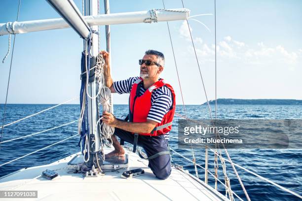 man in action of pulling rope - sail stock pictures, royalty-free photos & images
