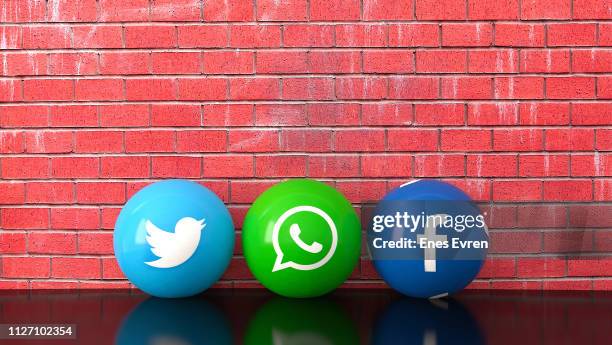 sphere shape of marble social media services icons including twitter, whatsapp and facebook with red brick wall - whatsapp stock pictures, royalty-free photos & images