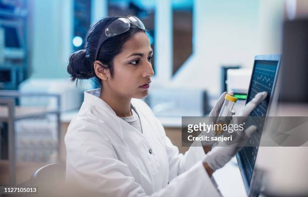 scienziata donna che lavora in laboratorio, usando lo schermo del computer - ricerca foto e immagini stock
