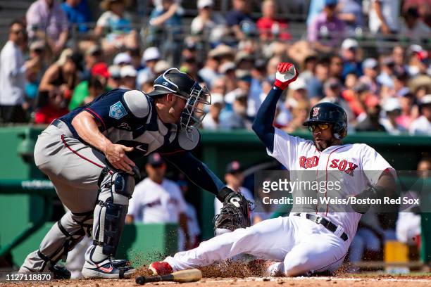 Eduardo Nunez of the Boston Red Sox slides as he evades a tag to score during the second inning of a spring training game against the Minnesota Twins...