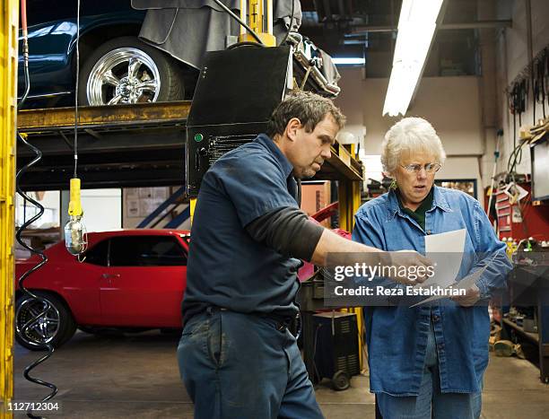 mechanic discusses invoices - old woman fixing car stock pictures, royalty-free photos & images