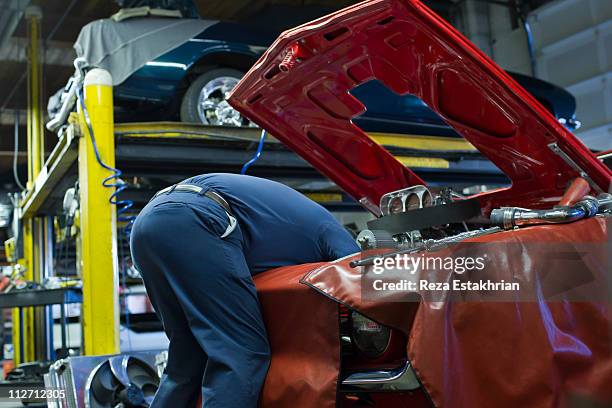 mechanic works deep inside engine - vehicle hood stock-fotos und bilder