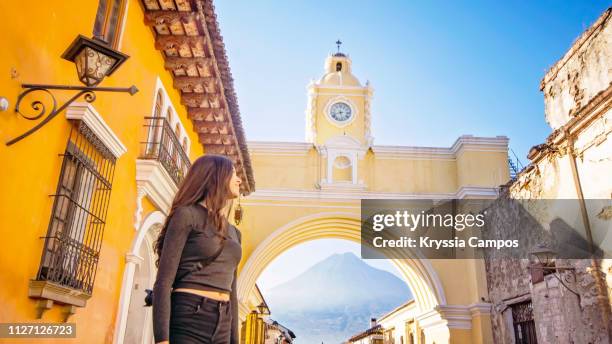 beautiful girl in front of arco de santa catalina (santa catalina arch) antigua guatemala - antigua western guatemala stock pictures, royalty-free photos & images