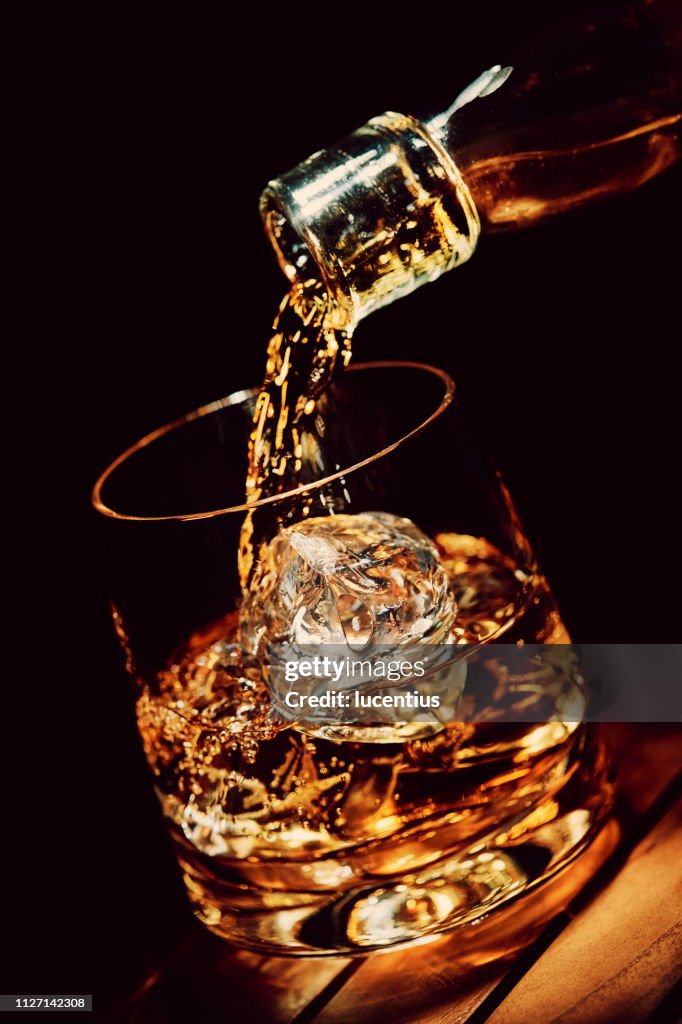 Pouring a glass of whiskey on ice
