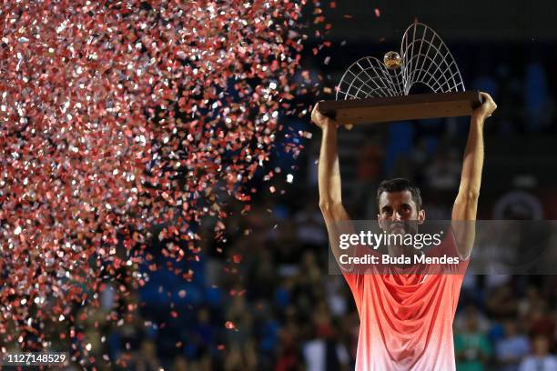 Laslo Djere of Serbia celebrates with the trophy after defeating Felix Auger-Aliassime of Canada at the singles final of the ATP Rio Open 2019 at...