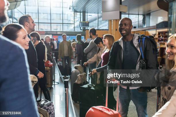 group of people standing in queue at boarding gate - crowded airport stock pictures, royalty-free photos & images