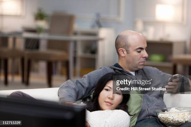 couple sur le canapé ensemble regarder la télévision - couple watching tv photos et images de collection