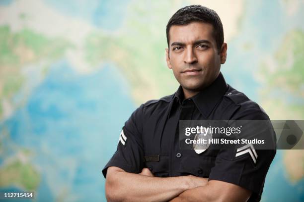 serious hispanic policeman with arms crossed - police uniform stockfoto's en -beelden