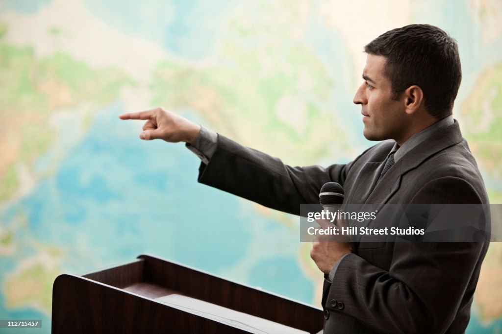 Hispanic businessman talking at podium