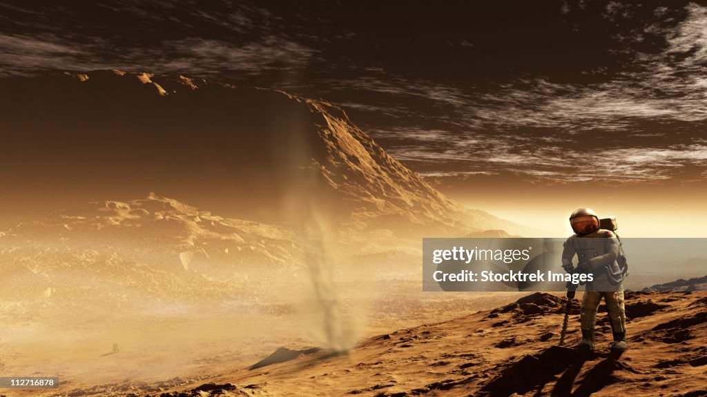 A lone astronaut drills into the regolith of Gale Crater.