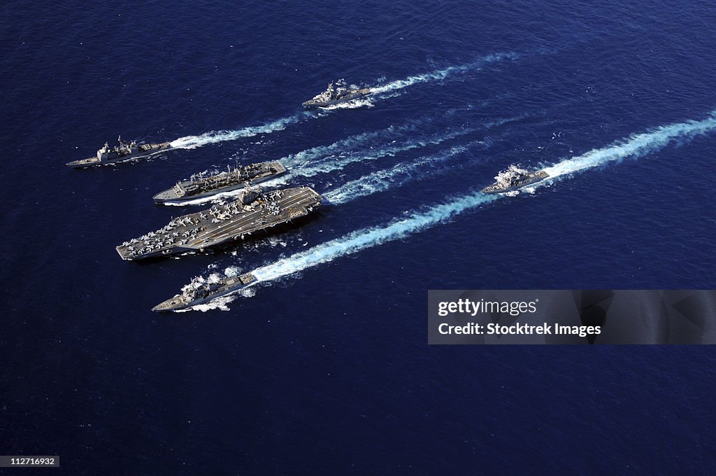 The Abraham Lincoln Carrier Strike Group ships cruise in formation in the Pacific Ocean.