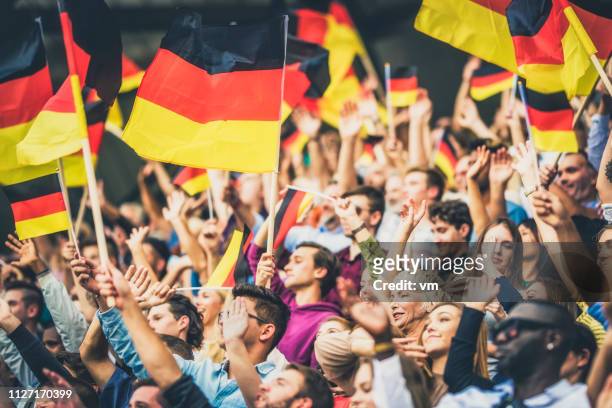 tifosi tedeschi sventolano le loro bandiere su uno stadio - campionato mondiale foto e immagini stock