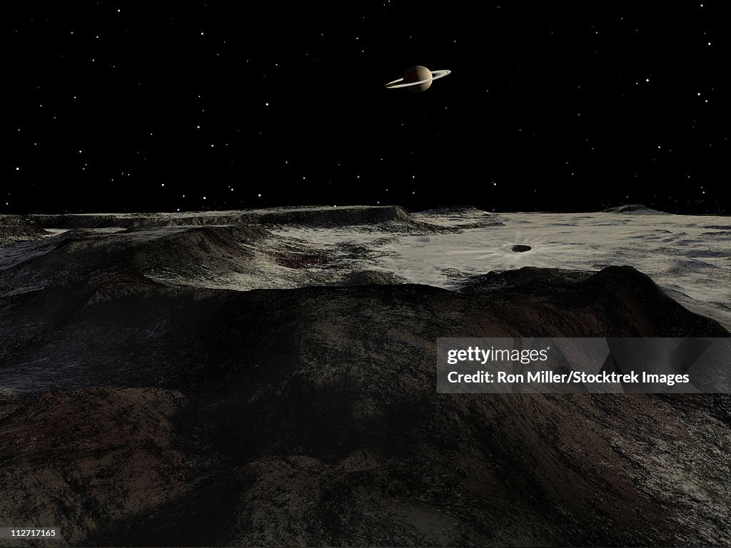 Saturn seen from the surface of its moon, Iapetus. Iapetus is divided into a bright hemisphere and a dark one. This is a scene on the dividing line.