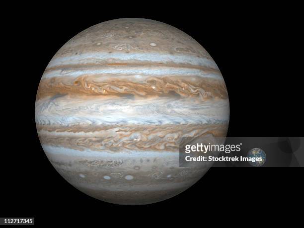 artist's concept comparing the size of the gas giant jupiter with that of the earth. - astrobiology stock illustrations
