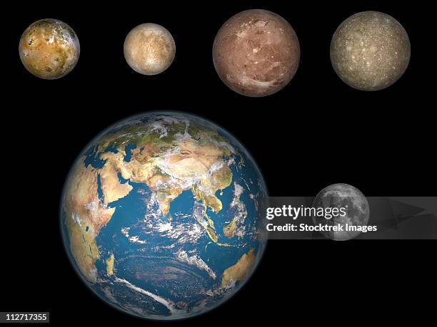artist's concept of jupiter's four largest satellites laid out above the earth and it's moon. - ganymede planetary moon stock illustrations
