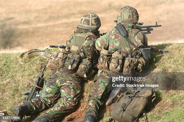 british army soldiers armed with general purpose machine guns participate in sustained fire training at brecon beacons, south wales. - british military stock-fotos und bilder