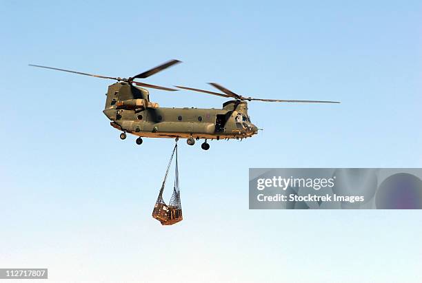 a ch-47 chinook of the royal air force transports a sling load of pallets. - military crate stock pictures, royalty-free photos & images