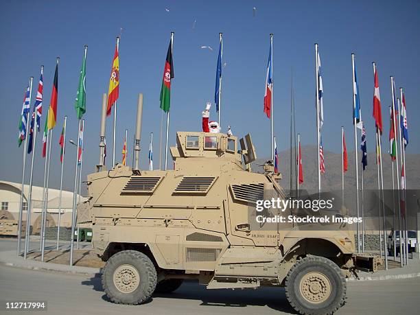 santa tosses candy from a maxxpro mine resistant ambush protected vehicle. - santa waving stock pictures, royalty-free photos & images