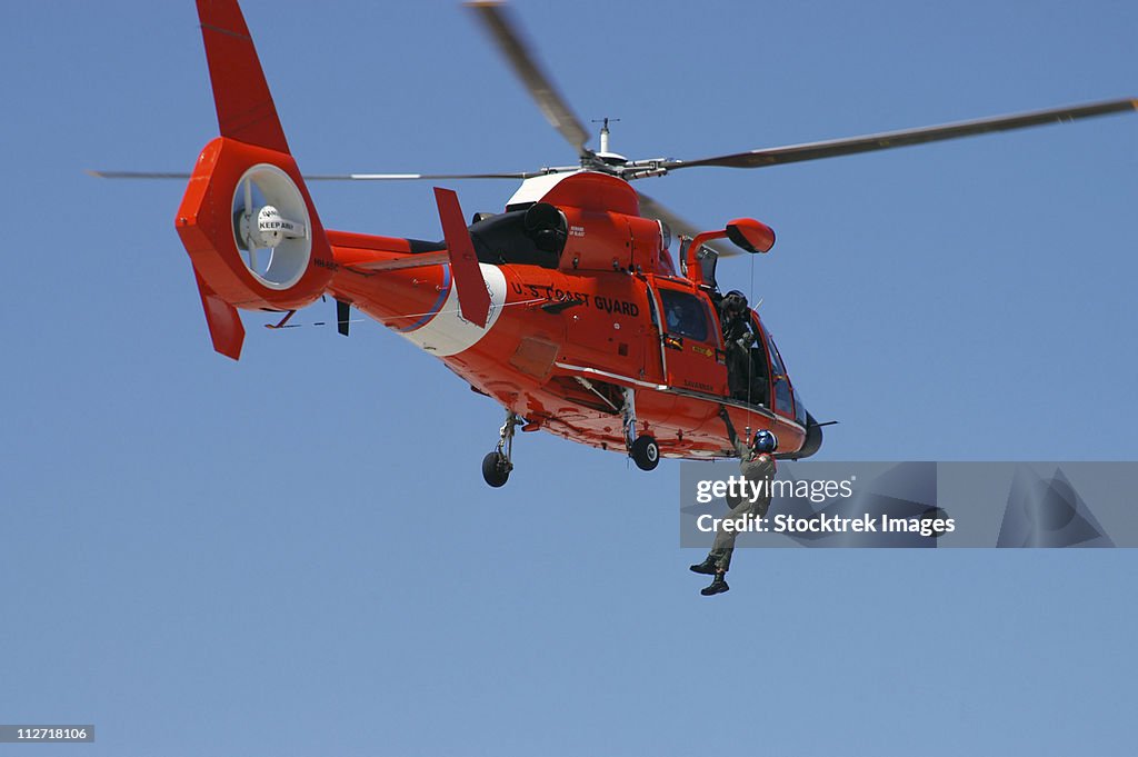 An HH-65C Dolphin demonstrates a helicopter rescue.