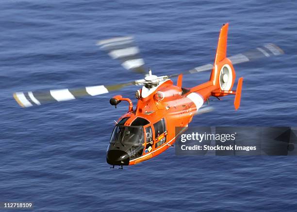 a coast guard hh-65a dolphin rescue helicopter in flight. - air ambulance stock pictures, royalty-free photos & images